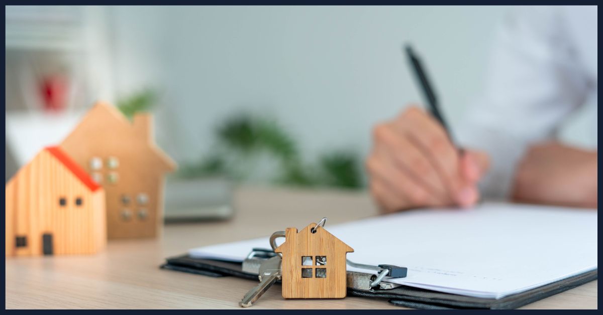 filling out papers with little home on desk
